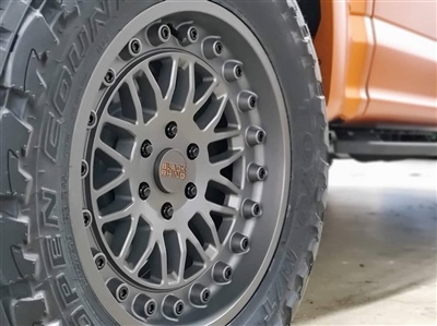 Close-up of a vehicle's custom alloy wheel with a detailed spoke design, mounted on a tire.