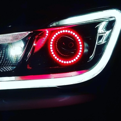 Close-up of a car headlight with a red circular LED light and a bright white LED strip