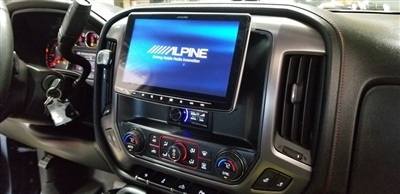 Close-up of a car dashboard featuring an Alpine touchscreen display, control buttons, and air vents.
