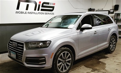 Silver Audi SUV parked inside a garage with "Mobile Installation Services" signage on the wall in the background.