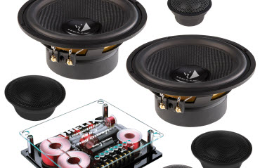 A set of car audio components, including two large speakers, two smaller speakers, and an electronic crossover unit, displayed against a white background.